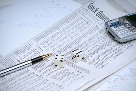 Rolling the dice on the stock market, with analysis sheets and a cell phone to make the buy/sell callの写真素材