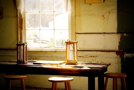 two old candle reading lamps by a windowの写真素材