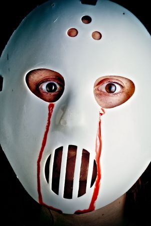 Cross processed image of a hockey mask with blood coming from the eyes.の写真素材