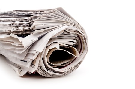 Horizontal view of a rolled up newspaper on whiteの写真素材