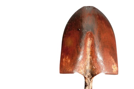an old steel gardening shovel covered with red clay dirtの写真素材