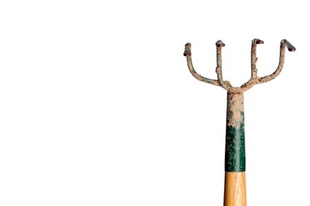 A horizontal view of a wood and metal garden hoe covered with dirt on whiteの写真素材