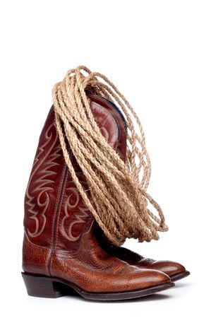 a vertical image of a pair of brown cowboy boots and a coil of rope on a white backgroundの写真素材