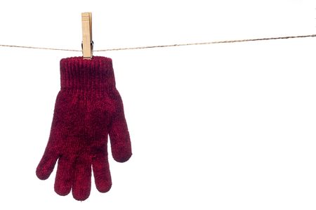 a horizontal image of a single red winter glove hanging on a clothes lineの写真素材