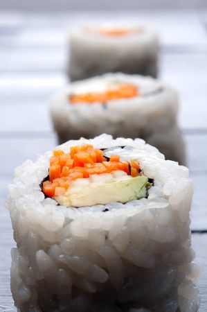 shallow focus vertical macro of 3 rolls of sushi