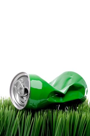 vertical close up of a green crushed aluminum drink can on grassの写真素材