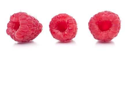 A horizontal image of three fresh raspberries on white