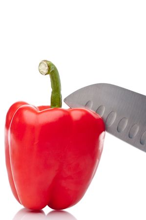 a vertical image of a red pepper being sliced on whiteの写真素材