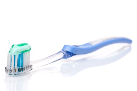 Horizontal shallow focus toothbrush with toothpaste on a white surfaceの写真素材