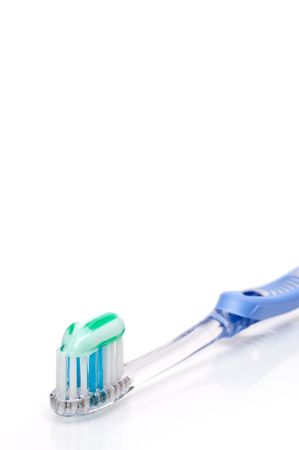 Vertical shallow focus toothbrush with toothpaste on a white surfaceの写真素材
