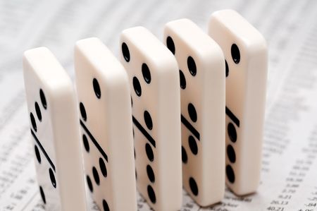 Horizontal image of dominoes on a newpaper stock reportの写真素材