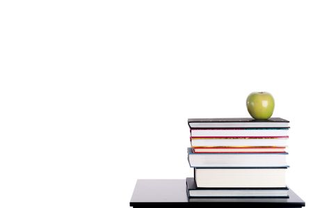 Horizontal image of a stack of books with a green apple on whiteの写真素材