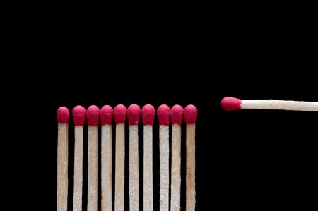 One different wooden match on black