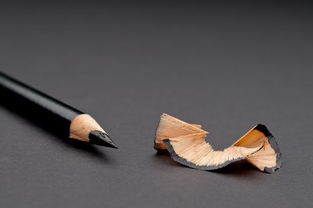 Horizontal close up of a sharpened black pencil with shavingsの写真素材