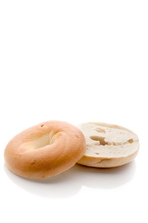 A sliced bagel on a white reflective backgroundの写真素材