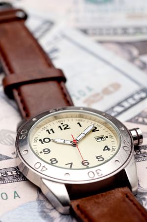 Vertical image of a wristwatch on American currencyの写真素材