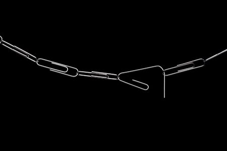 horizontal breaking paperclip chain on blackの写真素材