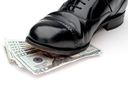 Horizontal image of a black leather shoe standing on a pile of moneyの写真素材