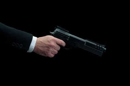 a man in a business suit firing a gun on blackの写真素材