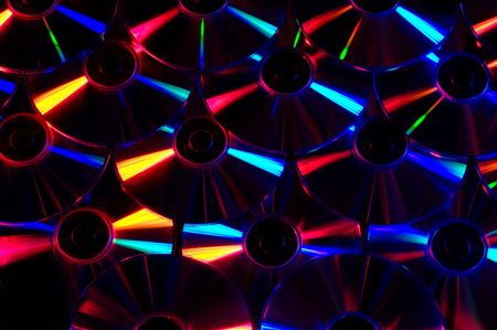 An array of computer CDs under colored lights