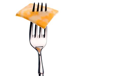 A horizontal image of a slice of marbled cheese on a silver fork on white with copy space to the rightの写真素材