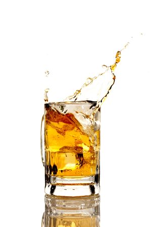 Beer splashing on a white reflective backgroundの写真素材