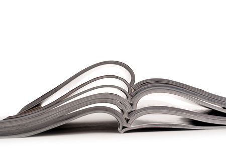 a stack of open magazines on a white backgroundの写真素材