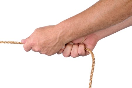 Male hands pulling on rope in a tug of war on whiteqの写真素材