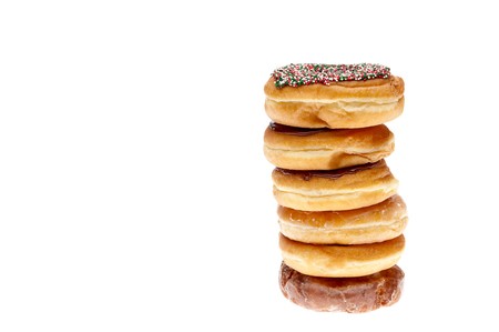 Horizontal image of a stack of fresh donuts isolated on whiteの写真素材