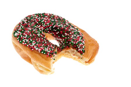 A single donut with chocolate icing and sprinkles with a bite taken out of it on whiteの写真素材