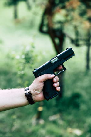 The gun is in his hand. The man is ready to shoot at the target.の写真素材