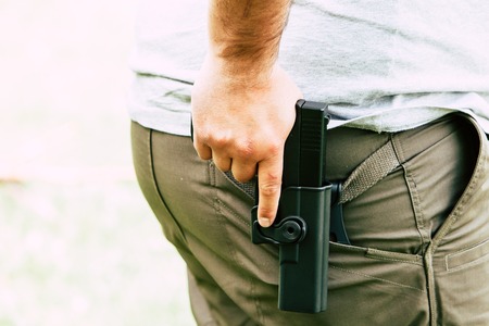 Pistol in the holster. The shooter trains. Is preparing to shoot at the targetの写真素材