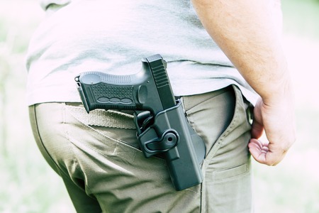 Pistol in the holster. The shooter trains. Is preparing to shoot at the targetの写真素材