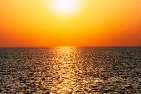 Dawn or sunset on the sea, the ocean, the lake. Beautiful view. The sun is visible.の写真素材