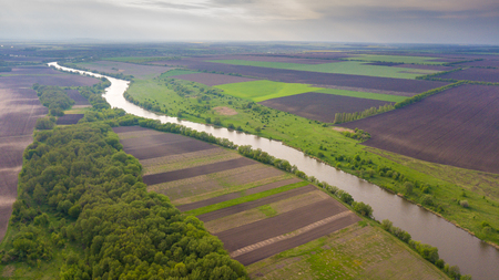 River and fields top view. Photographed from the drone. Beautiful view of the agropolis. Spring. Green fieldsの写真素材