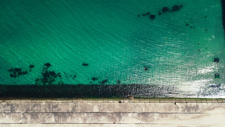 Top view of the sea, ocean. Vacationers on the sand by the water. Photographed from the droneの写真素材