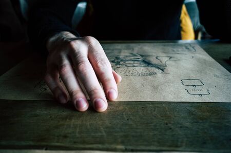 Male hand on the table in the restaurant. Dramatic photoの写真素材