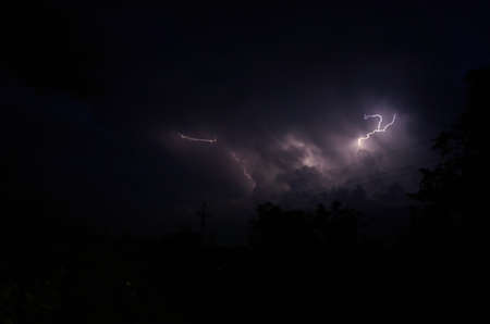 Lightning and thunderstorms in the night cloudy sky. Lightning sparkles through the clouds. Night...