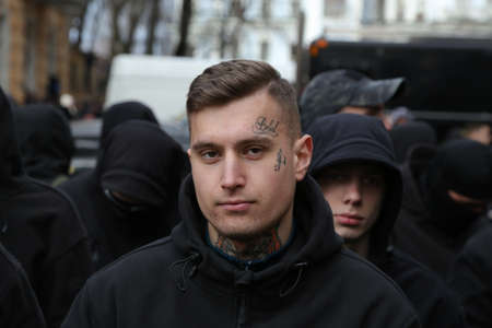 03.23.2019 Ukraine. Kiev. The political party National Corps holds a rally against theft in the army of Ukraine. Portraits of the protesters and the policeman. High quality photo.のeditorial素材