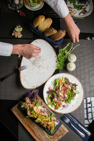 chef's hands are served at the Banquet table in the restaurant. Concept - decoration of the dining...