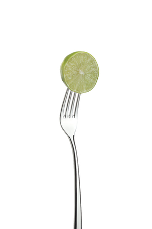 Shiny metal fork with lime isolated on white background