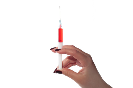 syringe with red liquid on an isolated white backgroundの写真素材