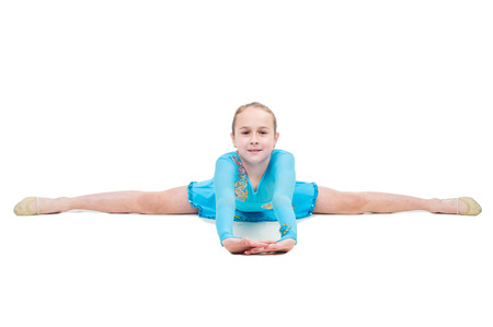 Cute little girl sits on a splits isolated on white backgroundの写真素材