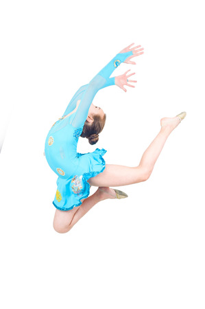 Cute young girl doing gymnastics isolated over whiteの写真素材