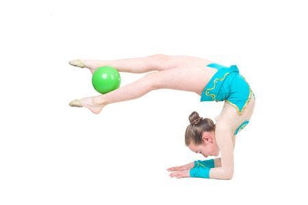 Little girl gymnast with green ball. Isolated on white background. Sporting exercise, stretch, flexibility, aerobicsの写真素材