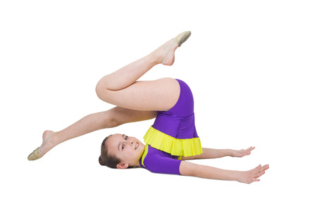 Cute young girl doing gymnastics isolated over whiteの写真素材