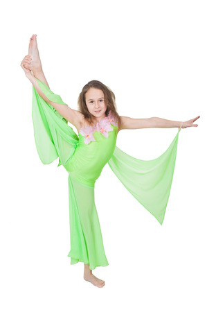 Cute young girl doing gymnastics isolated over whiteの写真素材