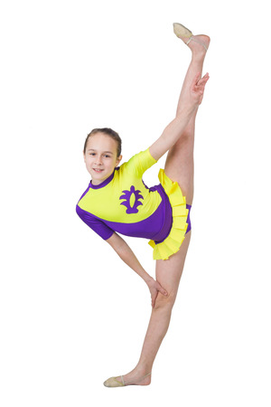 Cute young girl doing gymnastics isolated over whiteの写真素材