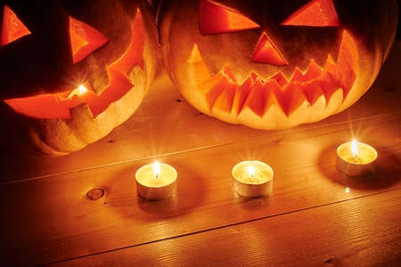 Halloween orange pumpkins jack lantern with candles on a wooden background in a rustic style. Beautiful autumn Pumpkins Halloween background with place for textの写真素材