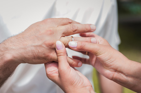 Bride Put the Wedding Ring on Groomの写真素材